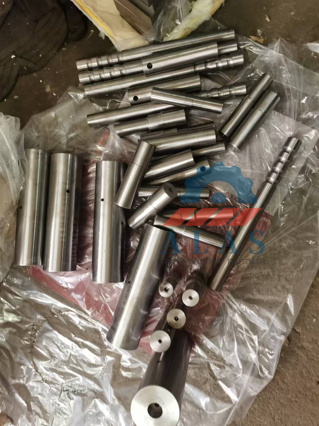 ALAS Custom Hardened Steel Rebar Bending Pins and Shafts Selection Una colección de piezas de repuesto para dobladoras de barras de refuerzo, incluidos ejes centrales, pasadores para doblar y mandriles formadores en varios tamaños.