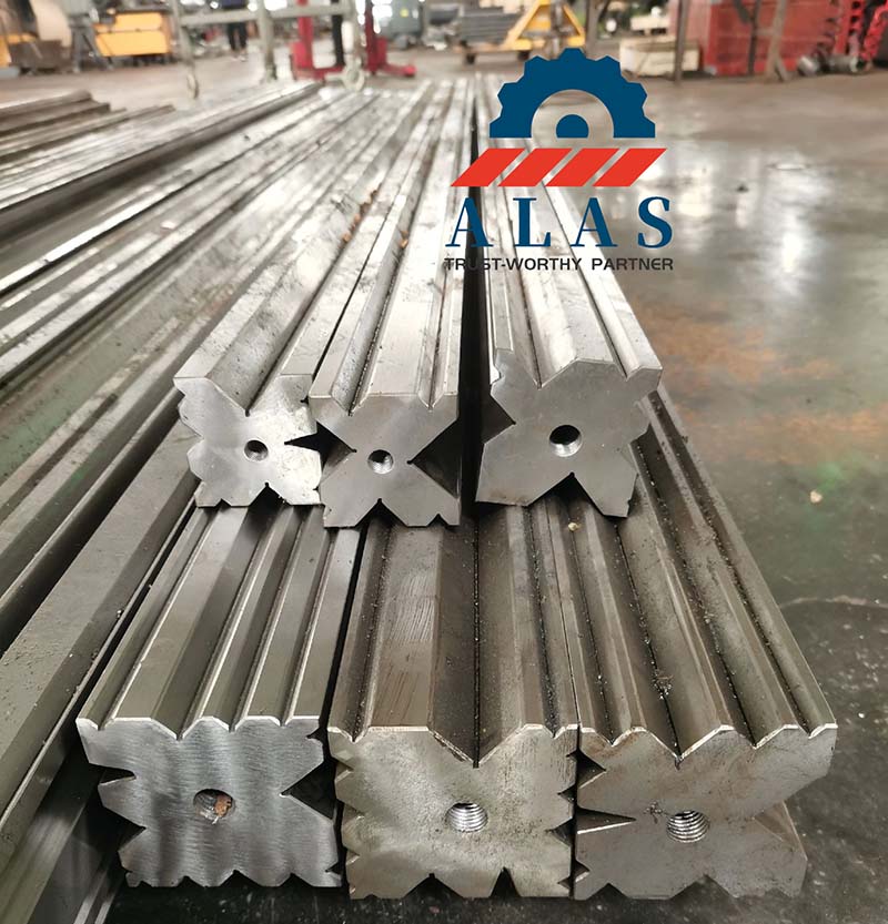 ALAS Heavy-Duty Multi-V Press Brake Lower Dies Stock Pila de troqueles para plegadoras de 4 vías de alta resistencia ALAS en fábrica, que muestra un gran perfil multi-V en forma de X y orificios centrales