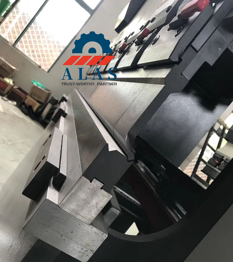 ALAS Multi-V 4-Way Press Brake Lower Die Operation View Bloque de troquel plegadora de 4 vías ALAS instalado en la bancada de una máquina dobladora hidráulica, que muestra herramientas de precisión multi-V