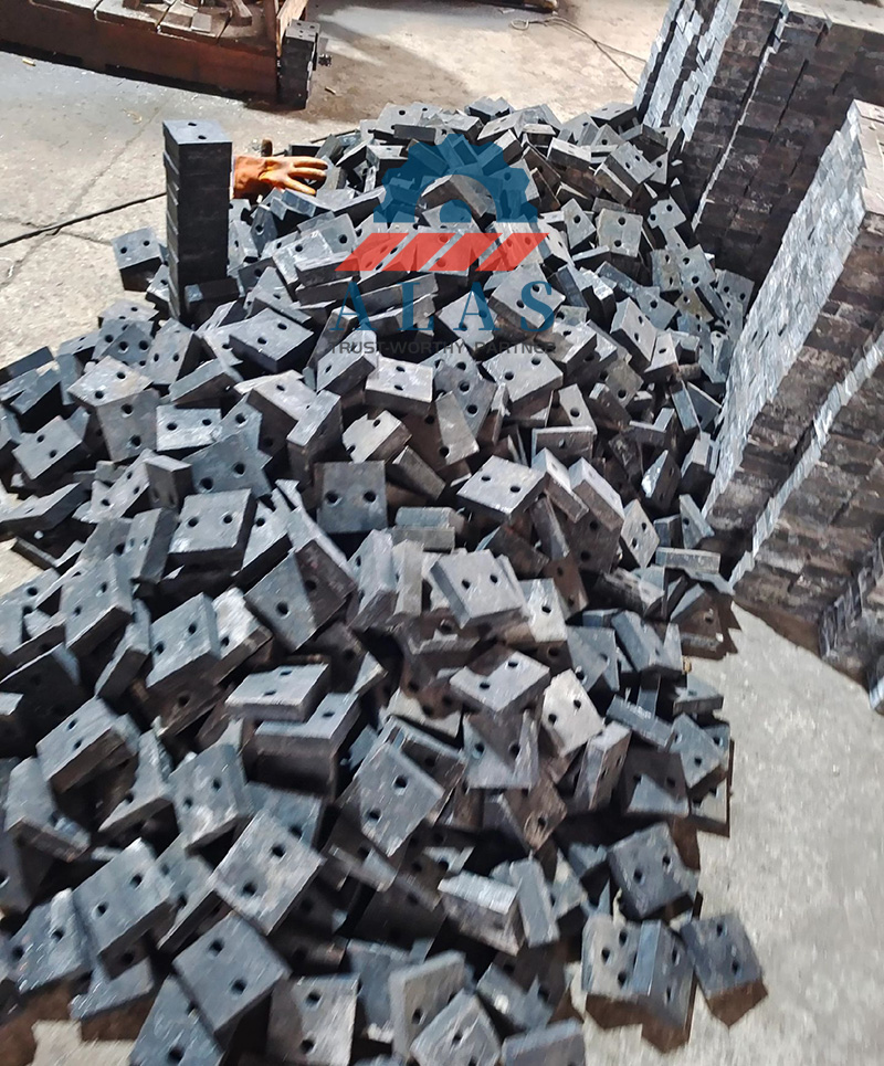 Una gran pila de cuchillas de corte de barras de refuerzo industriales a granel y cuchillas de corte de acero de alta resistencia apiladas en una f&aacute;brica listas para su distribuci&oacute;n al por mayor