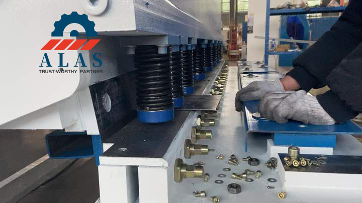 T&eacute;cnico experimentado ajustando una cuchilla larga de acero con alto contenido de carbono en una cizalla de guillotina hidr&aacute;ulica