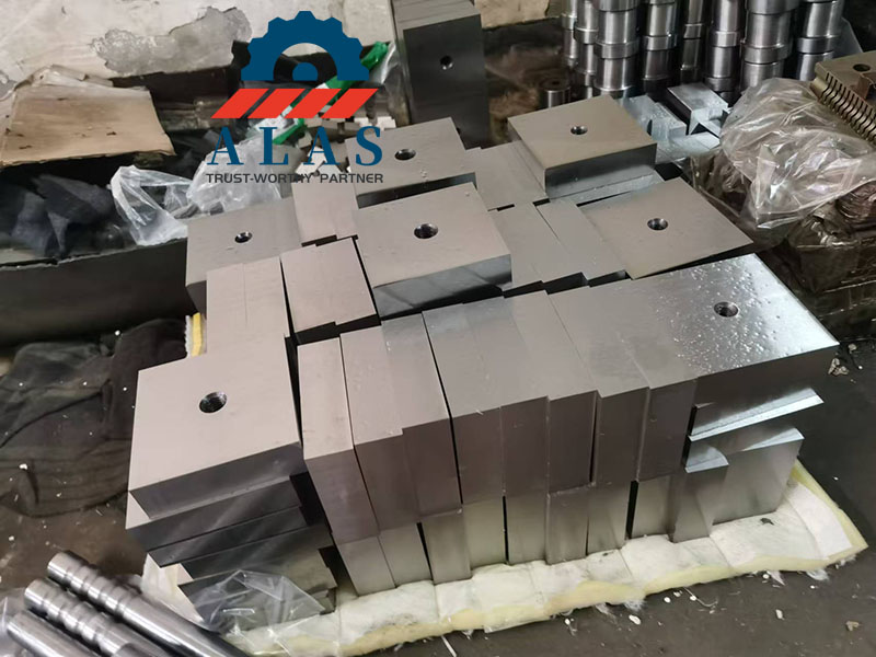 Fabricaci&oacute;n a granel de cuchillas cortadoras de barras de refuerzo de acero Cr12MoV y H13 apiladas en un taller de f&aacute;brica.
