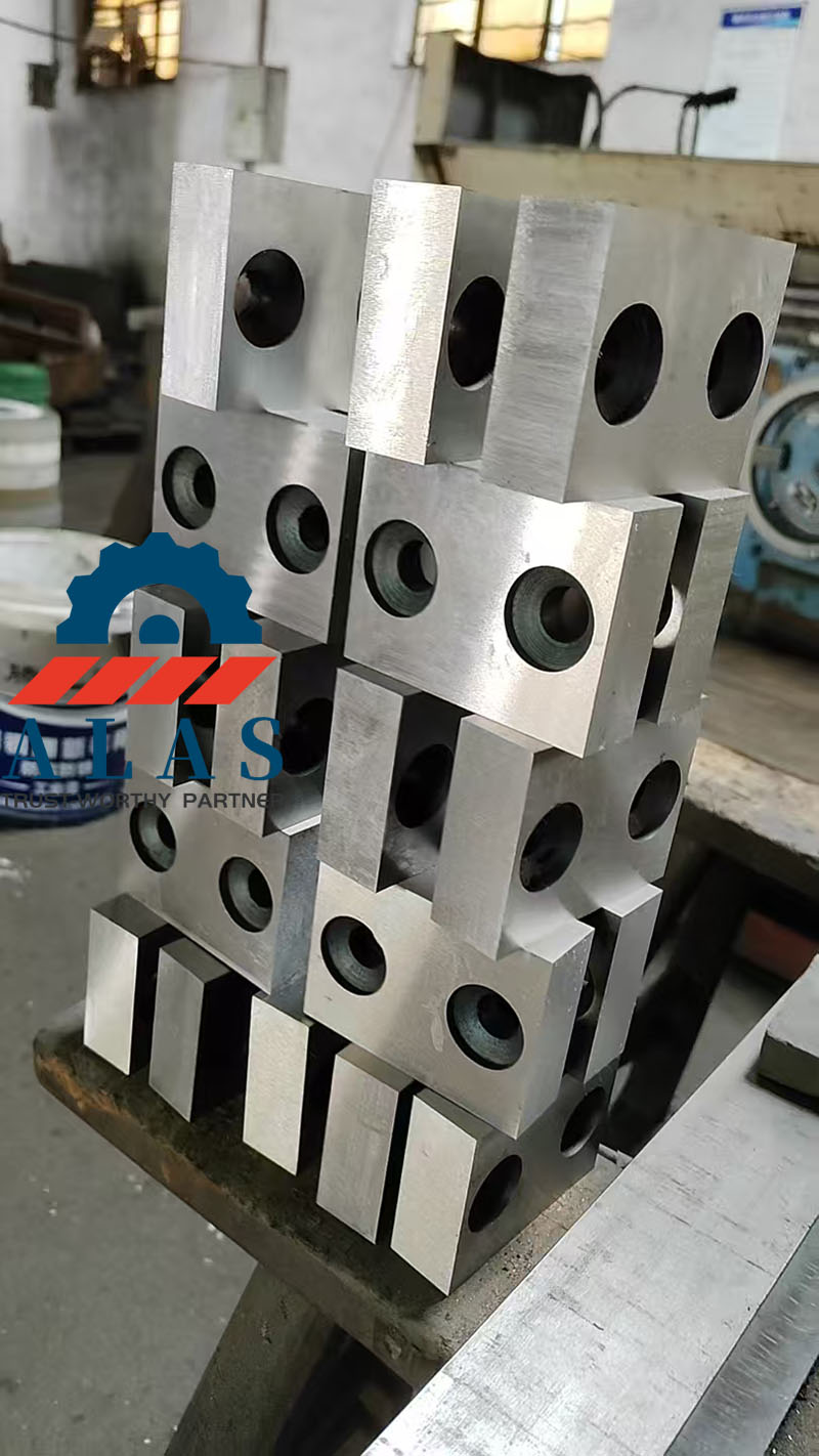 Cuchillas de corte de barras de refuerzo rectangulares de alta resistencia con orificios dobles apiladas en una f&aacute;brica de procesamiento de metales