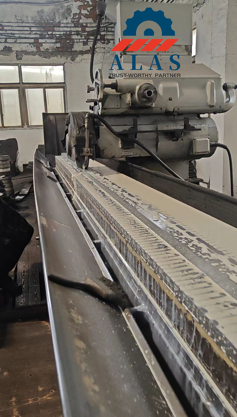 Una m&aacute;quina rectificadora de superficies de bancada larga para trabajos pesados ​​que procesa una hoja de m&aacute;quina de corte industrial extralarga en f&aacute;brica