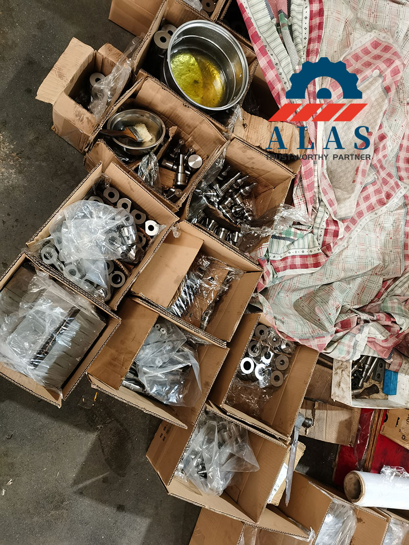 Repuestos de herrajes de alta resistencia empaquetados en cajas seguras con tratamiento de aceite industrial antioxidante en el taller de ALAS